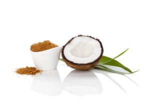 Coconut sugar in bowl and coconut half isolated on white background.